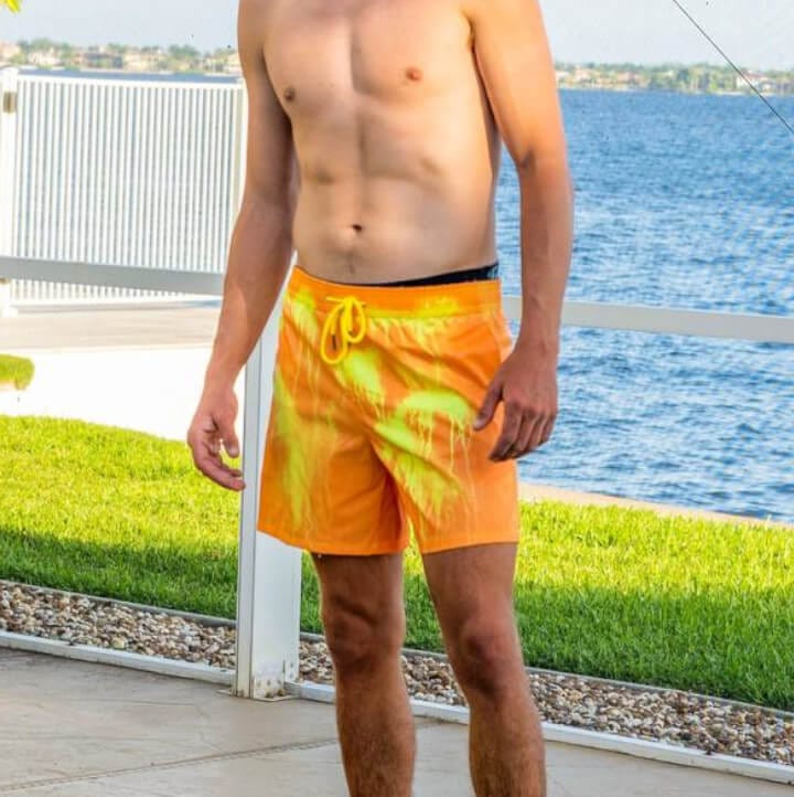 Costume arancione con colature gialle indossato in riva a un lago, dopo i primi schizzi d’acqua