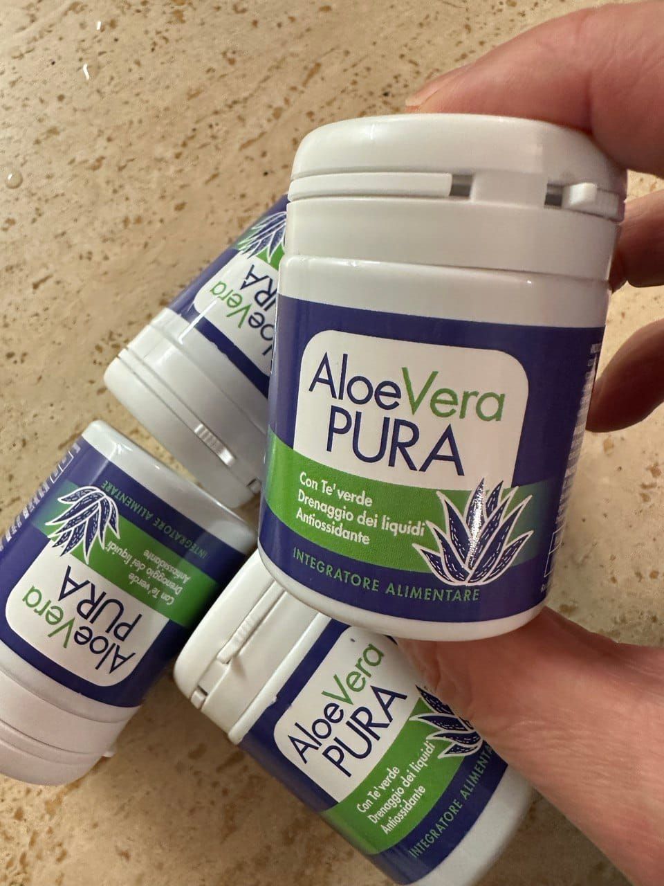 Barattolo di Aloe Vera Pura tenuto in mano, integratore alimentare con aloe vera e tè verde