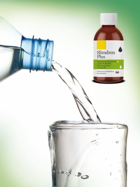 Acqua versata in un bicchiere accanto al flacone: il glucomannano va assunto con abbondante acqua