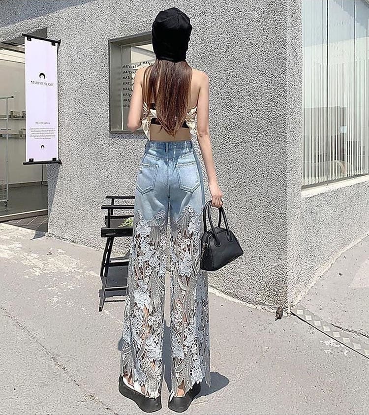 Ripresa da dietro: jeans a gamba larga con pizzo floreale traforato e tasche posteriori, in strada