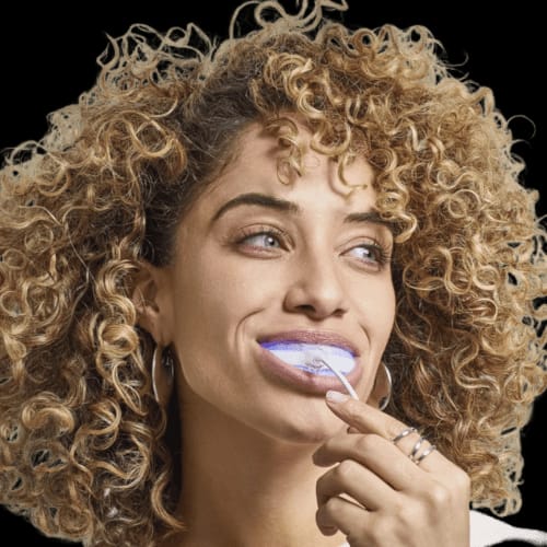 Dettaglio del bite a LED acceso in bocca, con la luce azzurra che illumina i denti