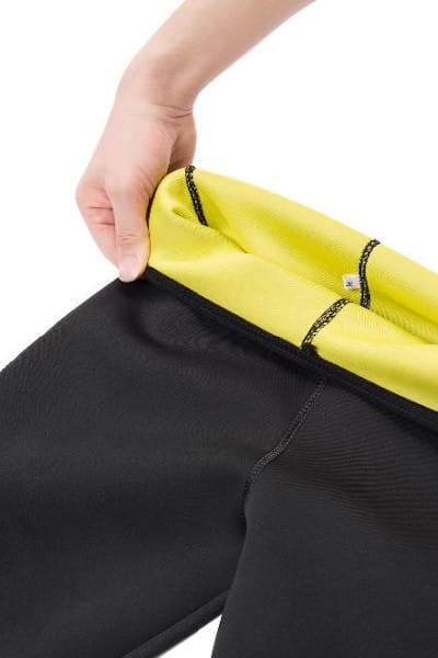 Dettaglio della vita: una mano scosta il tessuto e scopre la fodera gialla in neoprene con le cuciture a contrasto