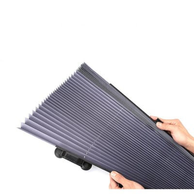 Due mani aprono a fisarmonica il telo plissettato blu scuro del parasole, su fondo bianco