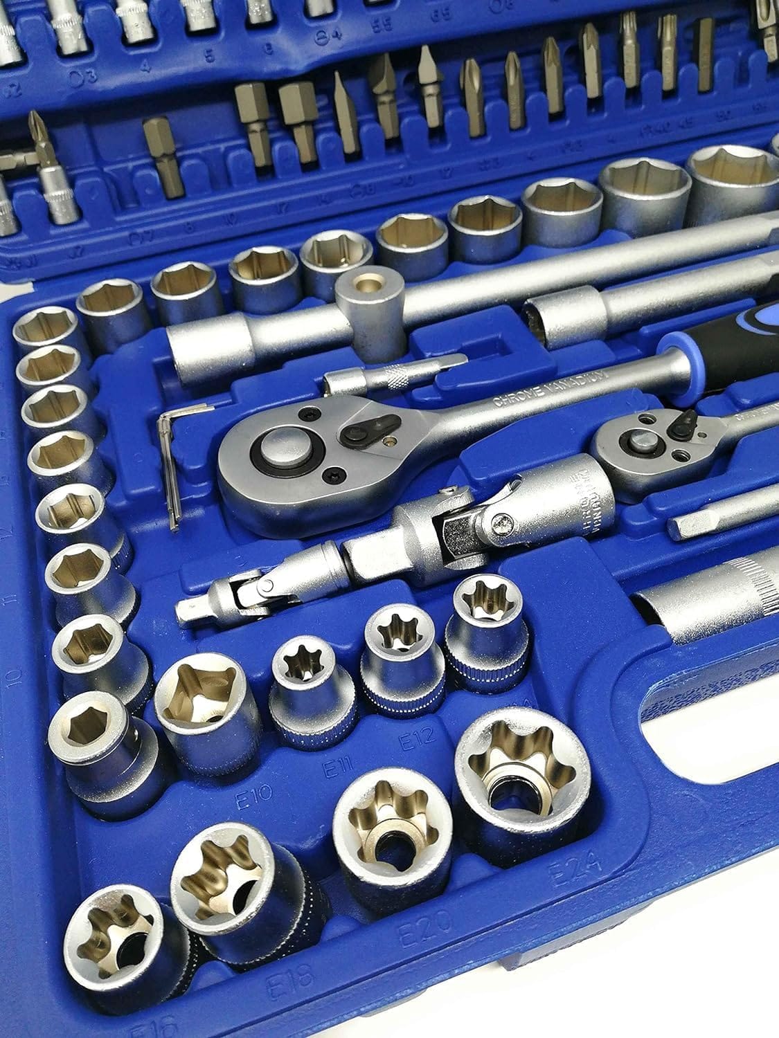 Primo piano delle bussole cromate, dei cricchetti e degli inserti torx negli alloggiamenti blu