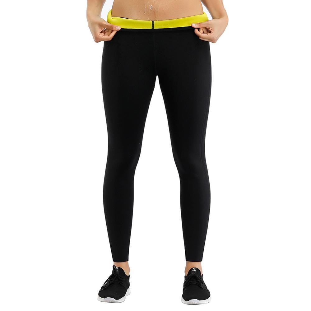 Leggings sauna indossati con scarpe da corsa: le mani tirano la fascia gialla in vita sopra il neoprene nero