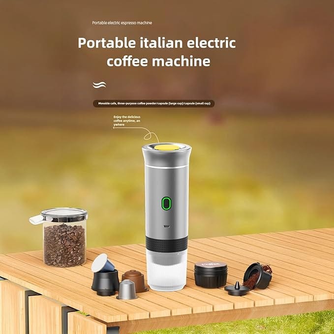 Macchina da caffè portatile a batteria su un tavolo in legno, con capsule e chicchi di caffè intorno